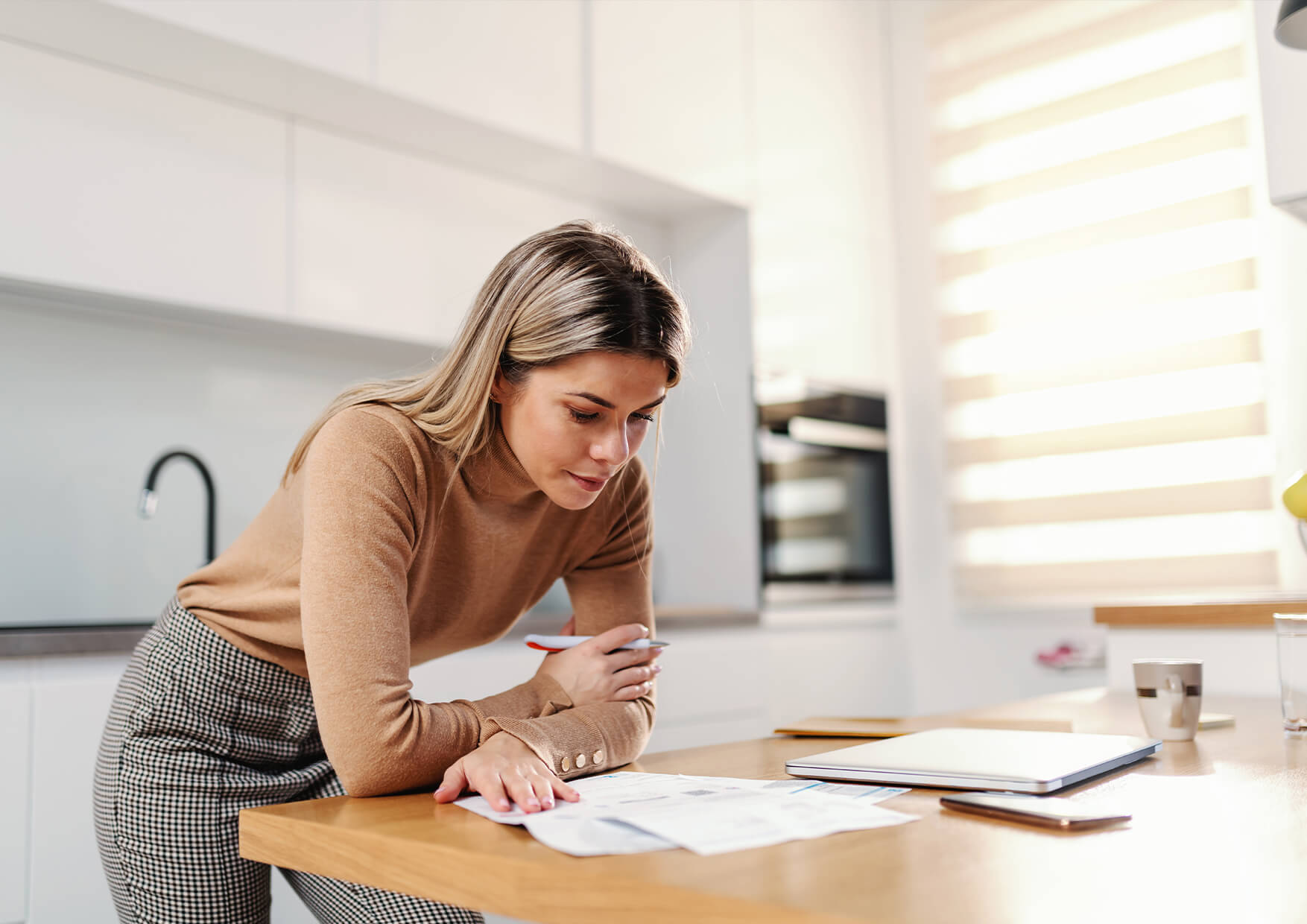 mujer en la mesa consultando papeles sobre los tramites relacionados con el contrato de la luz