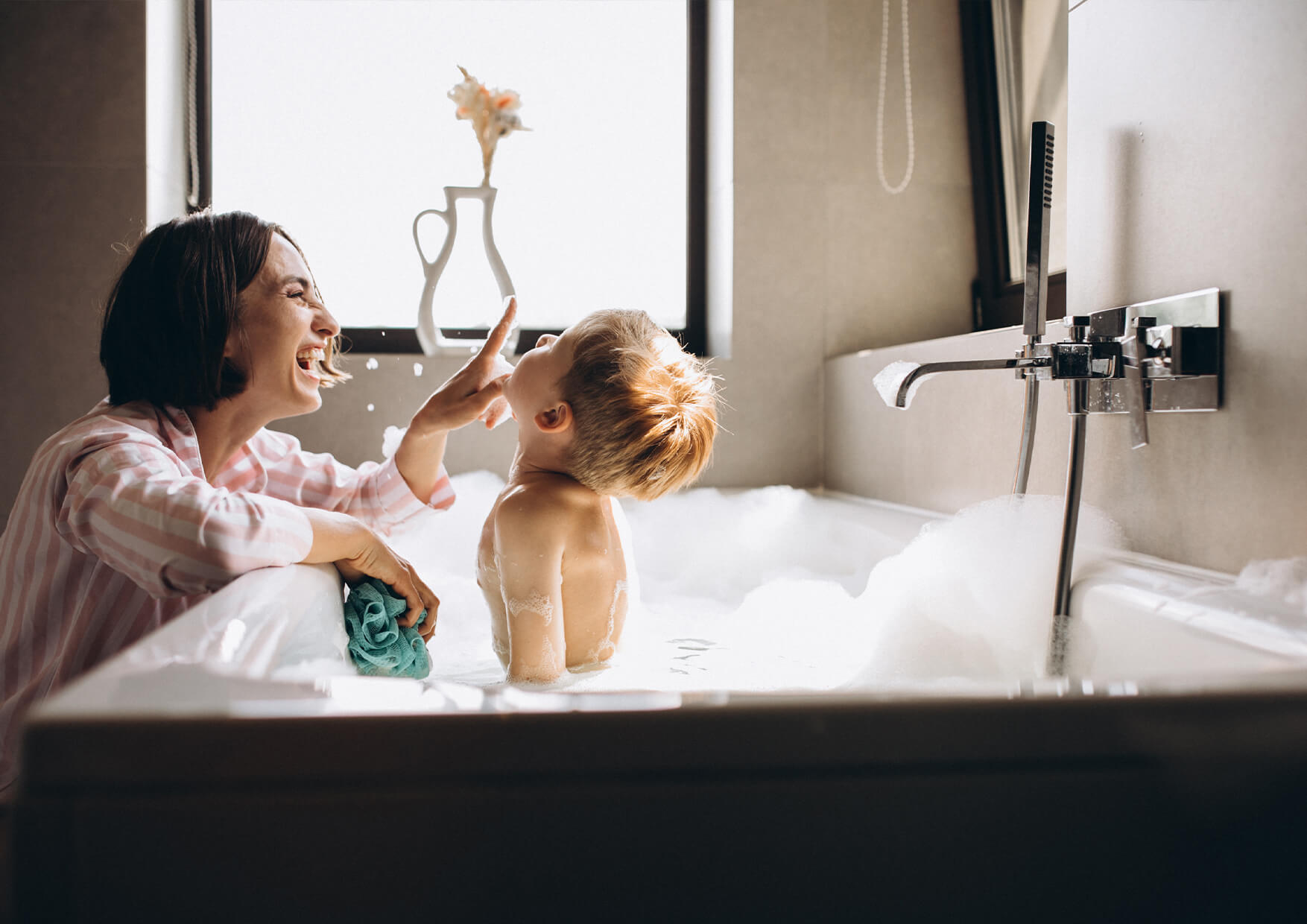 mujer jugando con su hijo en una bañera con espuma - cuanto cuesta instalar el gas natural