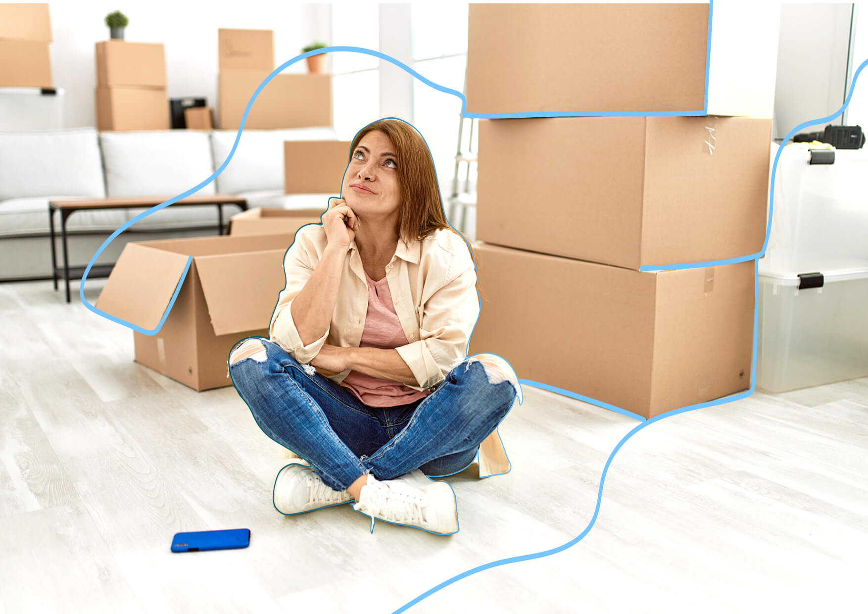 mujer sentada en el suelo con cajas de carton pensando que hacer con los contratos de gas y electricidad en una mudanza