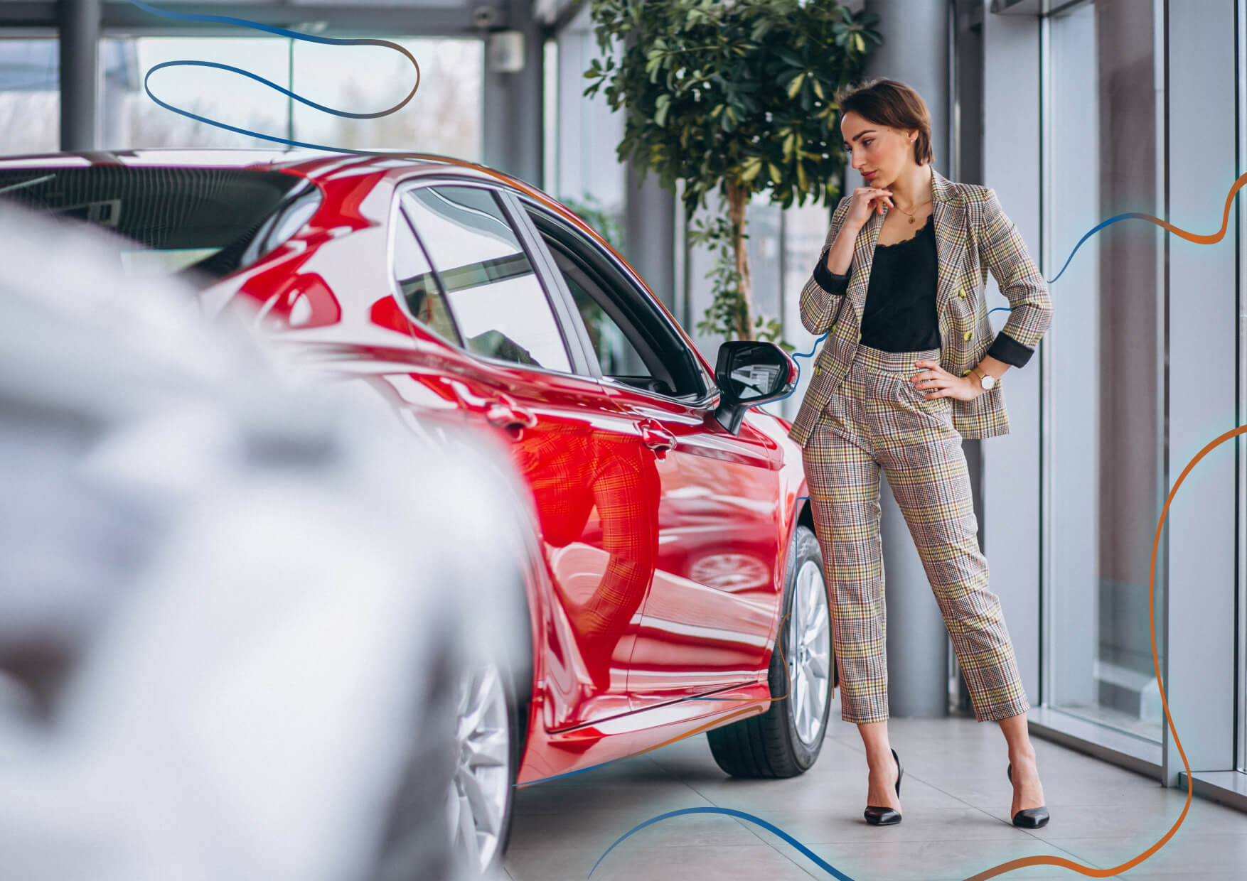 mujer al lado de un coche rojo en un concesionario pensando en las claves para encontrar coches electricos baratos